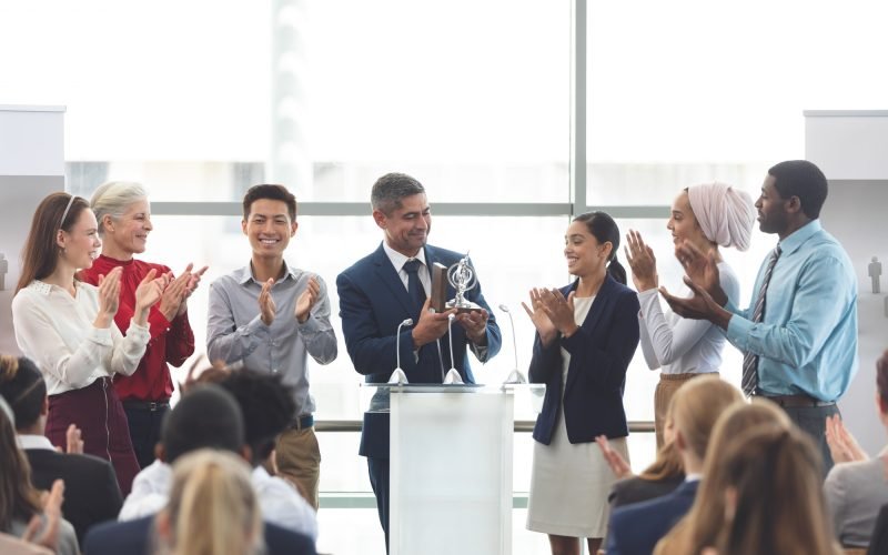 businessman-holding-award-on-podium-with-colleagues-at-business-seminar.jpg businessman-holding-award-on-podium-with-colleagues-at-business-seminar.jpg